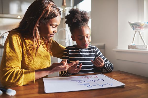 Image of a mom and daughter doing homework together.
