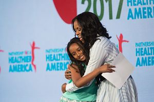 Image of a student hugging Michelle Obama after delivering Obama's  introduction at Partnership for a Healthier America's 2017 Building a Healthier Future Summit.