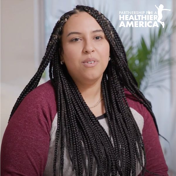 Perla from Lincoln, NE smiles while talking to the camera for PHA's Good Food for All storytelling project