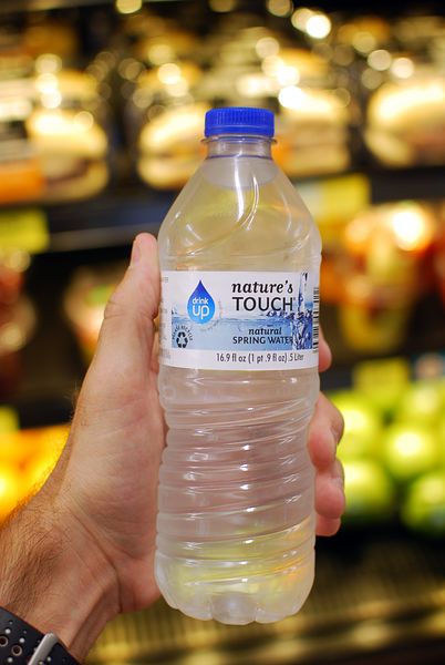 Image of a hand holding a Nature's Touch water bottle with PHA's Drink Up initiative logo on it. 