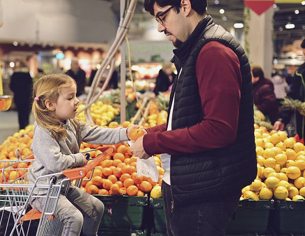 A father and daughter shop for groceries