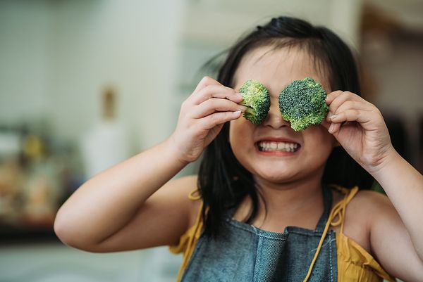 Child holding broccol