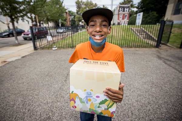 Boy holding a Pass the Love meal box