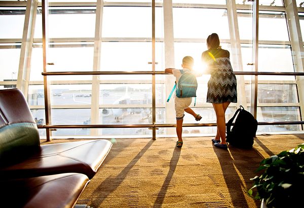 Family staring out the window at an airport. 