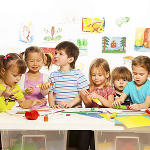 Image of preschool children at a table doing arts and crafts.