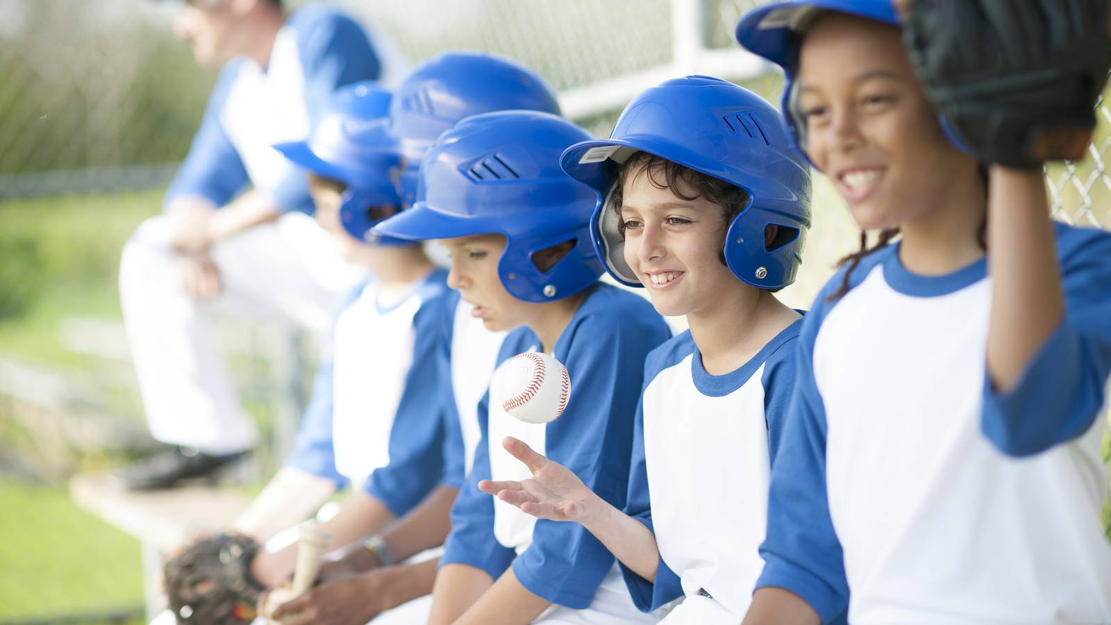 Kids baseball team sitting on a bench.