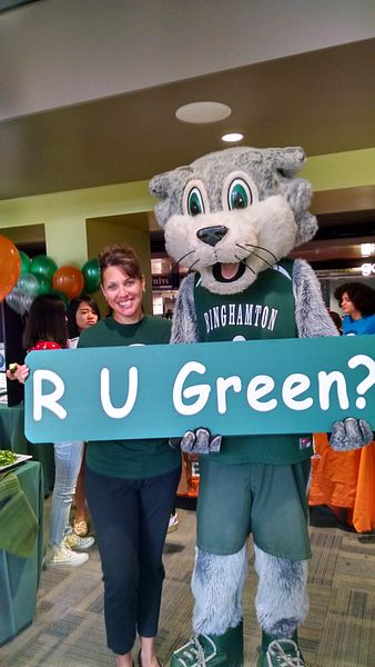 Student health fair at Binghamton University, a PHA partner participating in the Healthier Campus Initiative. Pictured are a student  and the university's mascot holding a sign that says "R U Green?"