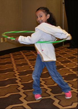 Image of a child hula hooping during on-site childcare provided by Bright Horizons Family Solutions at Partnership for a Healthier America's Building a Healthier Future Summit. 