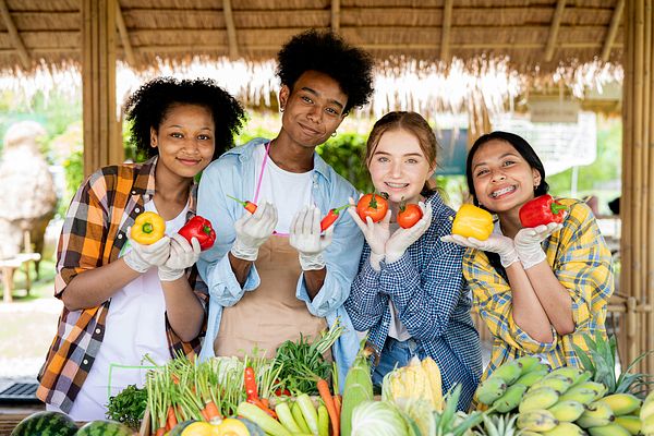 Image of teenagers smiling while holding produce