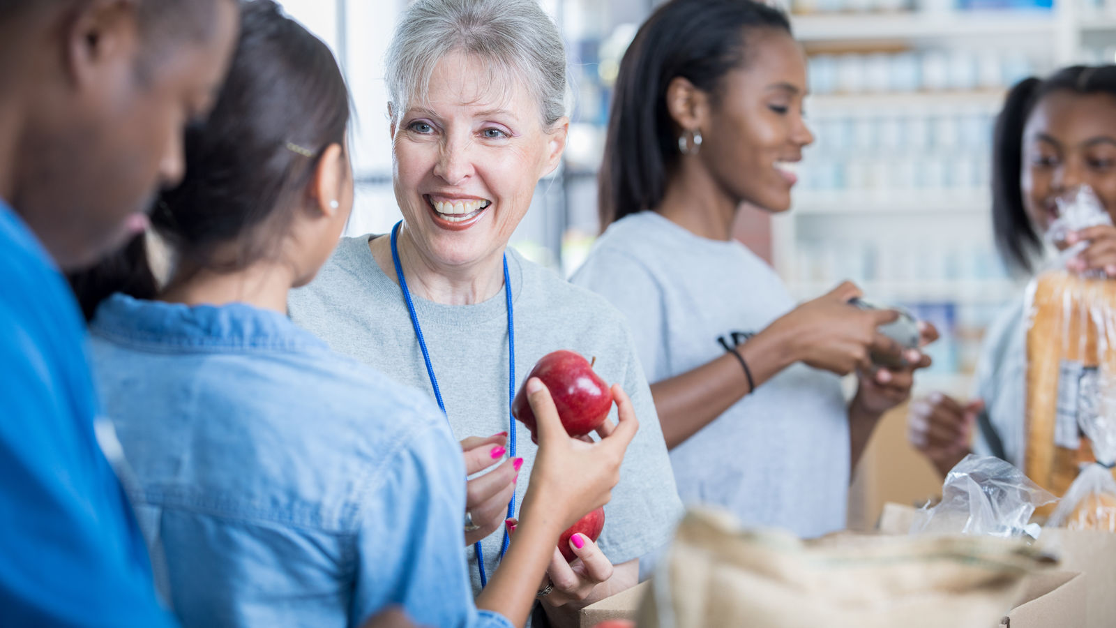 People Hold Apples at Foodbank
