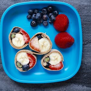 Fruit sushi roll with banana, strawberry and blueberries