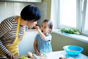 Daughter feeding her mother a carrot