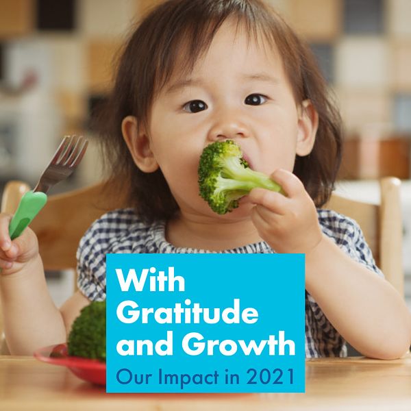 An image of our Impact Report banner with a little girl eating green vegetables