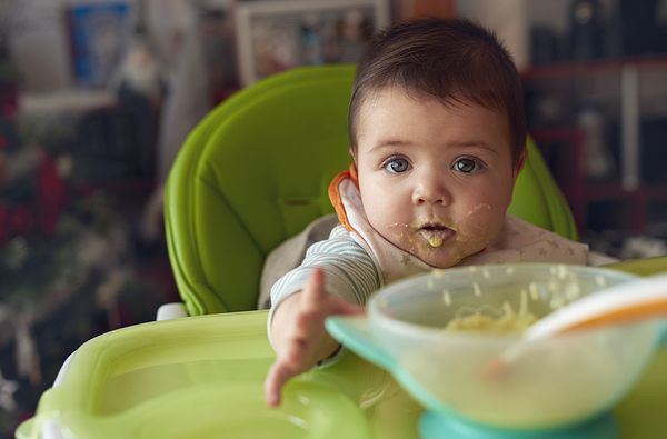 baby eating green vegetables