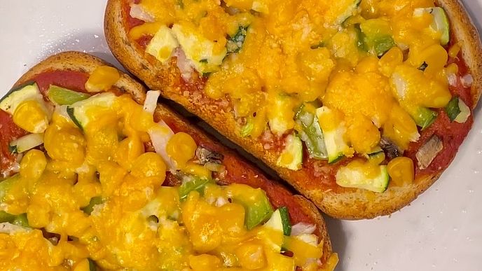 Toast with vegetables and cheese on it.