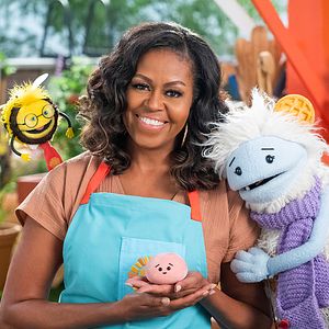 Waffles and Mochi characters posing with former First Lady Michelle Obama