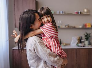 Mom and child hugging in the kitchen
