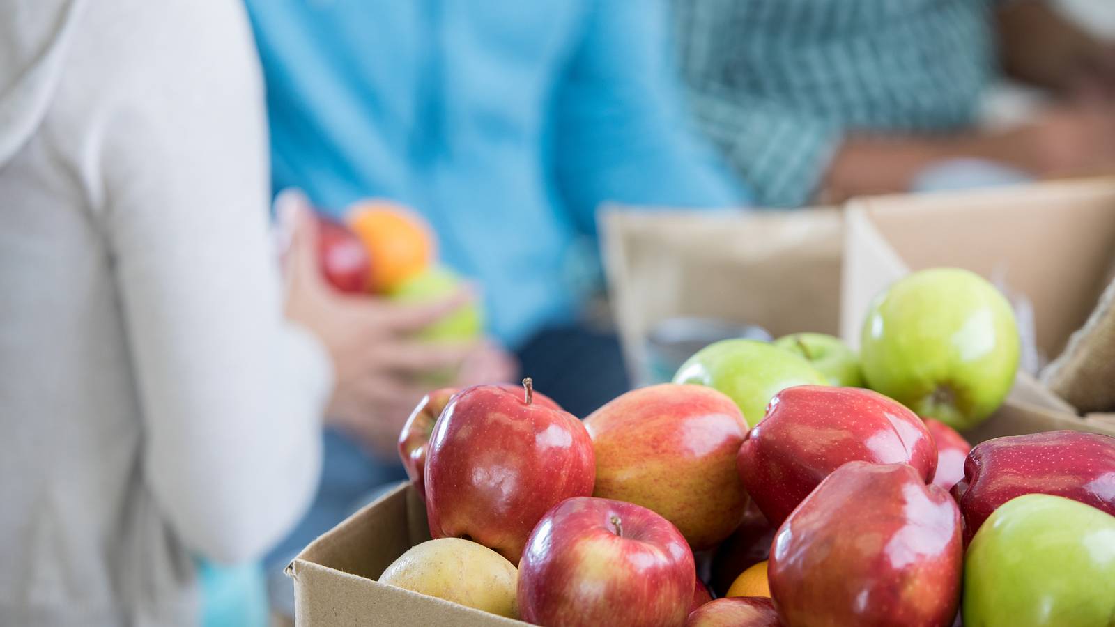 Image of a box of donated apples in a food bank. 