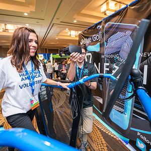 A volunteer at Partnership for a Healthier America's 2018 Innovating a Healthier Future Summit tests Blue Goji's virtual reality treadmill on the event Expo floor. 
