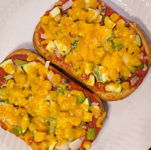 Toast with vegetables and cheese on it.