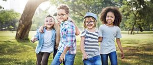 Image of a group of diverse children walking in a field.