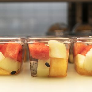 Image of fresh cut fruit in plastic packaging at a convenience store.