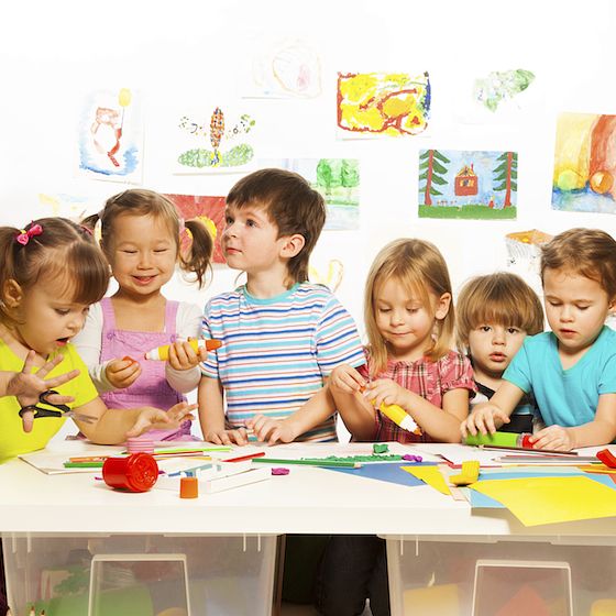 Image of preschool children at a table doing arts and crafts.