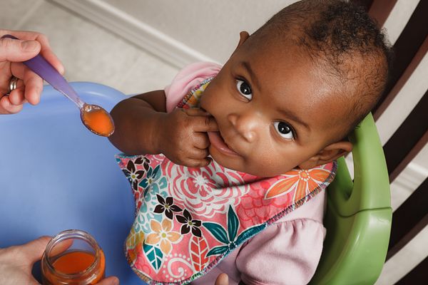 Baby being spoon fed vegetables